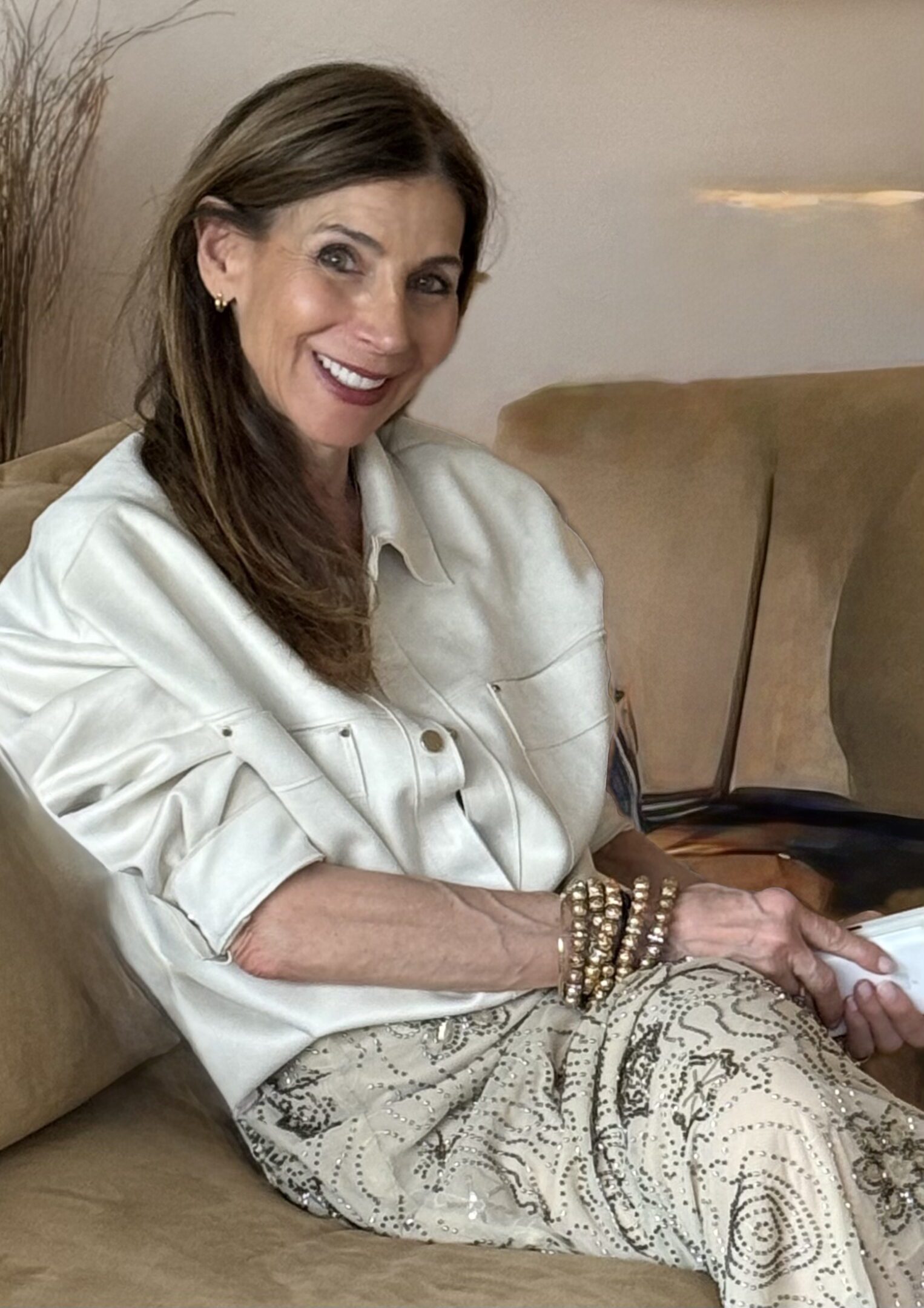 Smiling woman seated on beige couch
